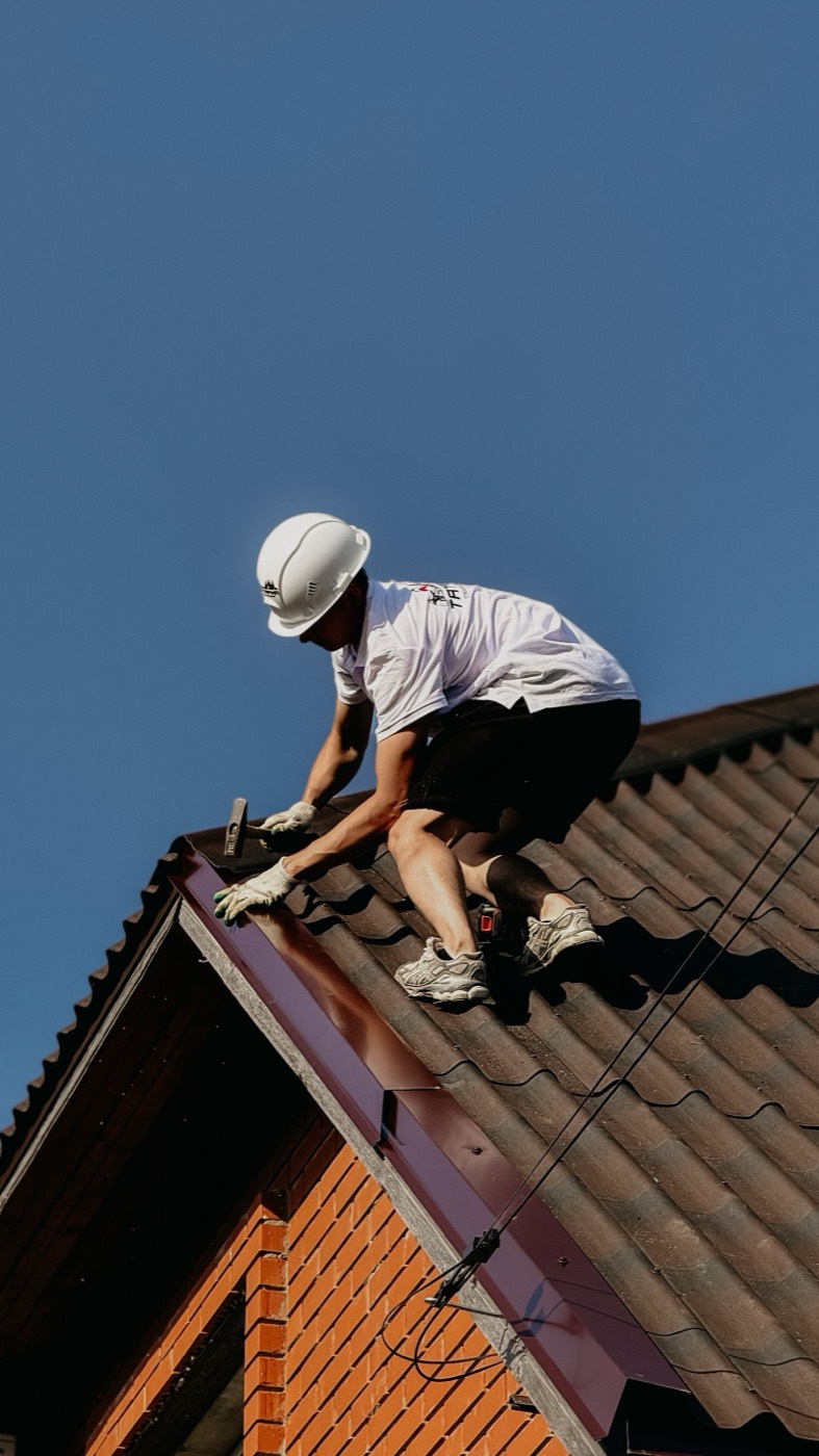 Dachdecker repariert einen Dachfirst
